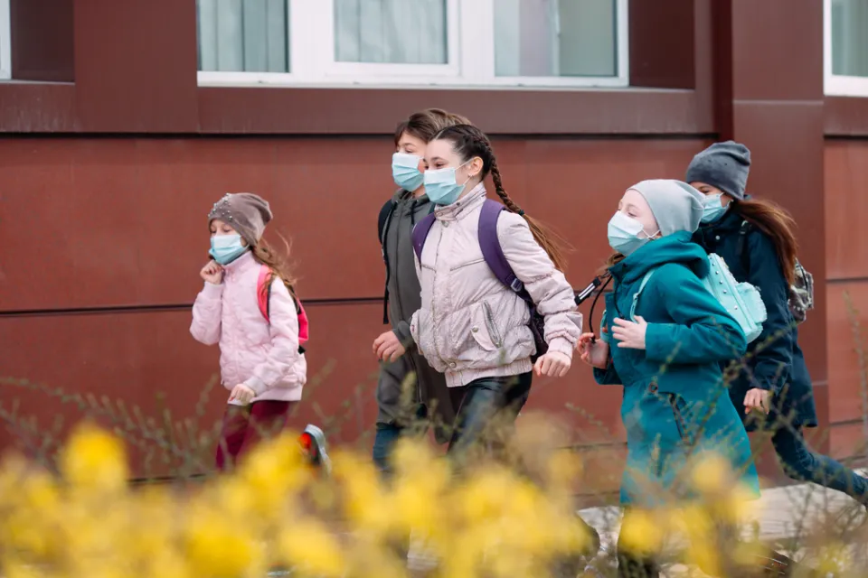 Group of children dressed warmly and wearing COVID-19 masks